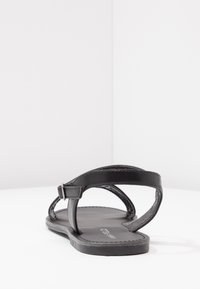 Sorte lær sandaler med tynde remme, åben bag og flad sål. Designet inkluderer detaljeret syning og en minimalistisk stil.