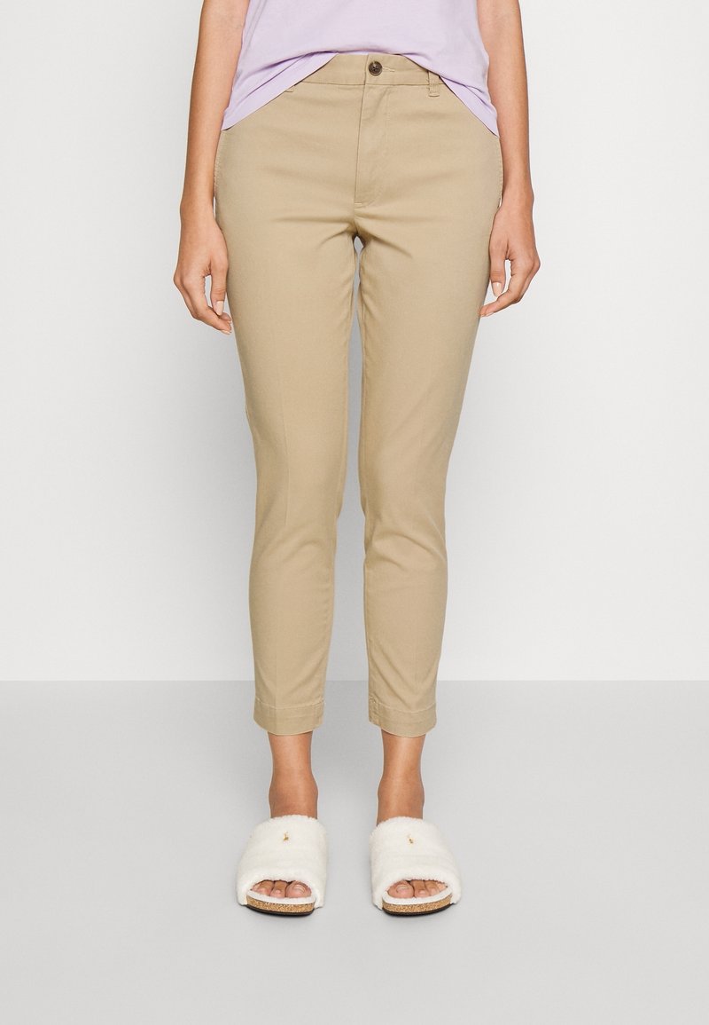 Khakifärgade chinos med slim fit, med knappstängning och ankellång nederkant. Mjuk tyg med en slät yta. Bärs med vita, fluffiga tofflor.