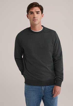Dunkelgrauer Pullover mit langen Ärmeln, Rundhalsausschnitt, gerippten Bündchen und Saum, kombiniert mit blauen Jeans. Glatte, weiche Textur.