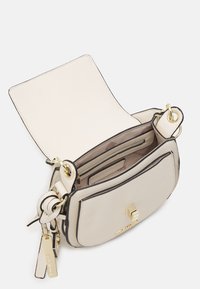 Beige kožená kabelka s černými detaily, vybavená zlatým uzávěrem a kováním. Otevřený design odhaluje podšívku s kapsami.