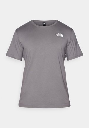 Camiseta gris de manga corta hecha de una tela suave. Presenta un escote redondo y un pequeño logo blanco en la parte superior izquierda.