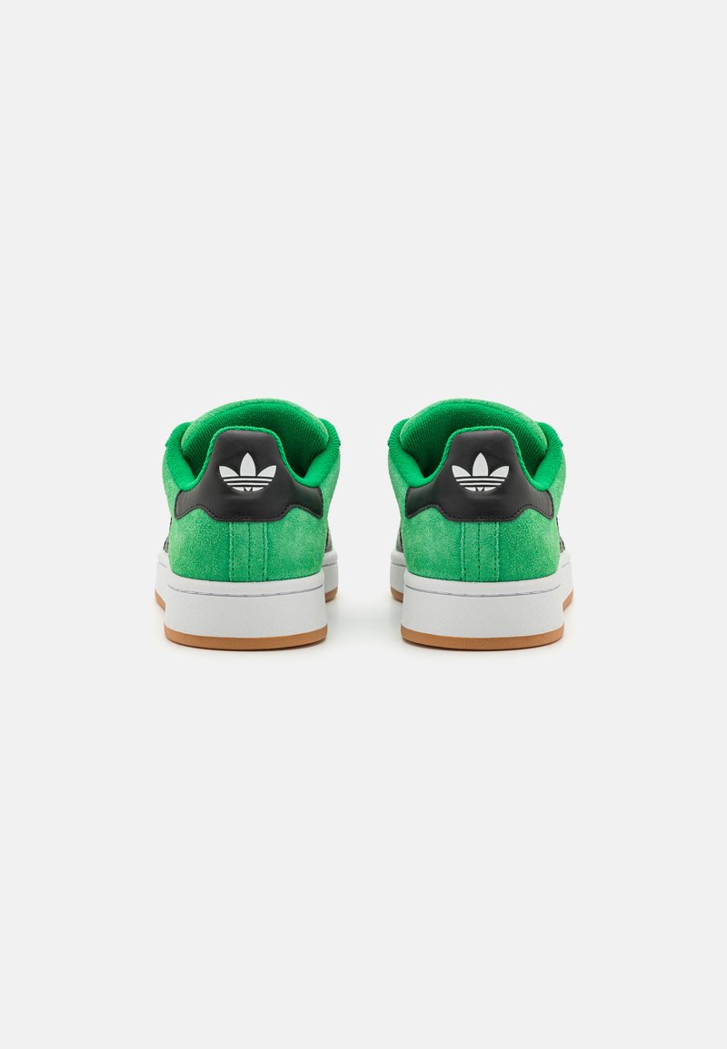 Zielone zamszowe sneakersy z czarnym hakiem na pięcie i białym logo. Gumowa podeszwa z brązowymi akcentami, niskoprofilowy design i wyściełany kołnierz.