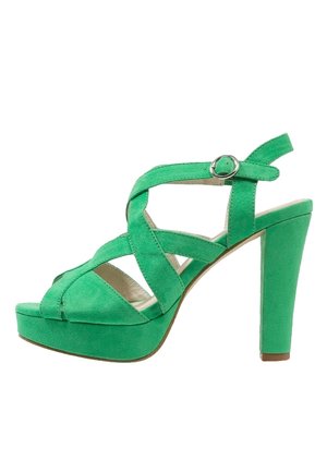 Sandale à talons hauts en daim vert avec un design à brides croisées, accent de boucle et semelle plateforme. Dispose d'un talon épais pour plus de stabilité.