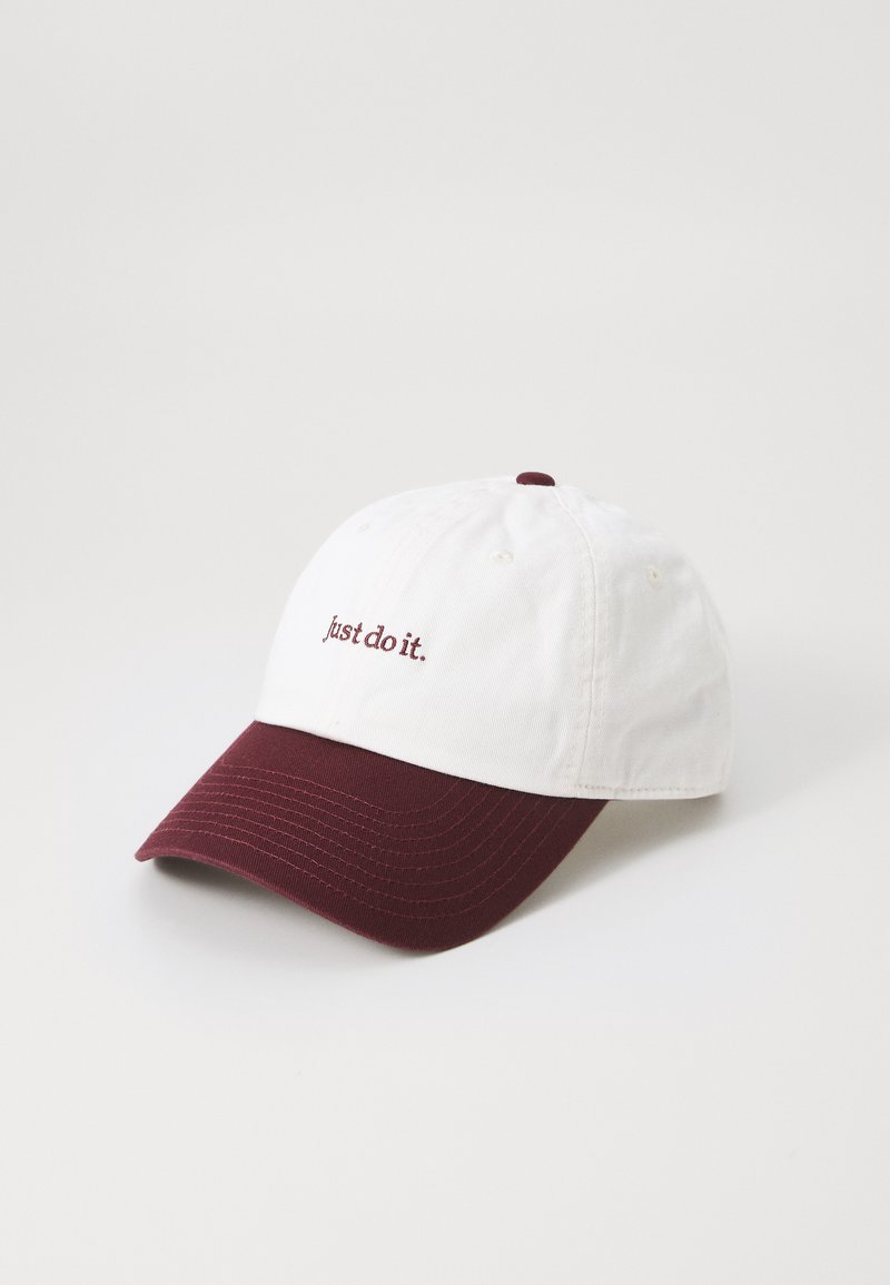 Hvit baseballcap med burgunder brem og "just do it." brodert i burgunder på fronten.