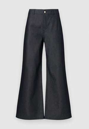 Tamsiai mėlyni laisvi džinsai su aukštu liemeniu, su priekyje esančiu sagčių uždarymu, diržo kilputėmis ir lygiu paviršiumi. Švarus dizainas be matomų raštų.