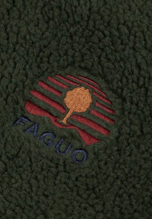 Groene fleece stof met een textuur oppervlak. Bevat een geborduurd logo in tinten rood en bruin, dat een boom en strepen weergeeft. De tekst zegt "FAGUO."