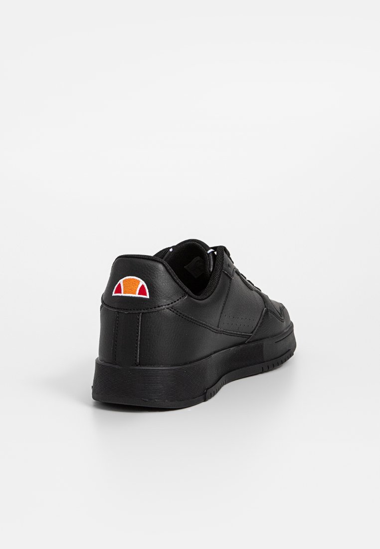 Zapatilla negra de cuero con un acabado suave, que presenta un diseño de perfil bajo con cordones y un parche de logo en naranja y rojo en el talón.