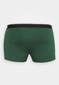 Zöld pamut boxer alsónadrág fekete derékrésszel és fehér díszvarrással. Karcsú fazon, sima felülettel és minimális részletezéssel.