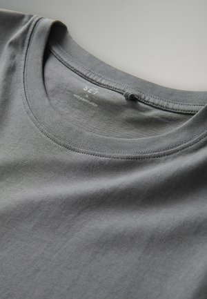 Grijze katoenen t-shirt met ronde hals, plat gelegd, met zichtbare gestikte halslijn en bedrukt binnenlabel met merk- en maatgegevens.