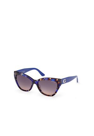 Lunettes de soleil en œil de chat avec une monture en écaille de tortue bleue et multicolore et des verres dégradés. Elles présentent un accent doré sur la branche.