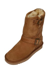 Bruine suède enkelboot met een faux fur voering, voorzien van twee verstelbare banden met metalen gespen en een gestructureerde rubberen zool.