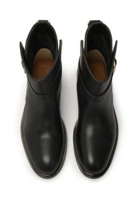 Black leather ankle boots with a smooth surface, rounded toe, side zipper, and decorative strap with a gold accent on the collar.