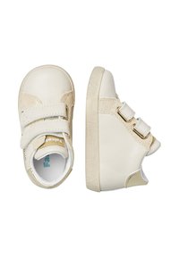 Scarpe per bambini in pelle beige con due cinturini in velcro, punta rotonda, tacco testurizzato e suole in gomma. Presentano sottili accenti dorati.