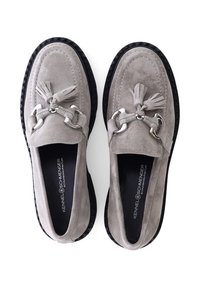 Grijze suède loafers met kwastjes, zilverkleurige hardware en een getextureerde zwarte rubberen zool. Heeft een ronde neus en een slip-on ontwerp.