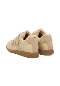 Beige színű sportcipők tépőzáras pántokkal, velúrból és sima bőrből készült anyagokkal, bolyhos bélésse és texturált gumitalppal. Lekerekített sarokkal és puha felülettel.