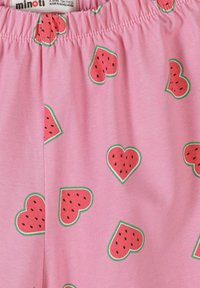 Tissu rose avec une ceinture élastique présentant un motif répété de tranches de pastèque en forme de cœur rouge, avec une croûte verte et des graines noires.