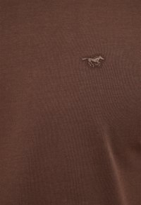 Brown cotton T-shirt featuring a small embroidered horse logo. The fabric has a smooth texture and a fitted design.