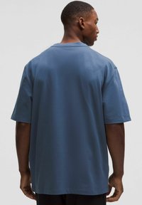 Túlméretezett, rövid ujjú póló tompa kék színben, puha pamutból, klasszikus nyakkal és megerősített varrással az alján.
