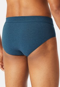 Culotte da uomo in cotone blu con un morbido elastico in vita, caratterizzate da una texture liscia e un design snello, che mettono in risalto una vestibilità aderente sul retro.