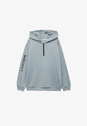 Hellblaues Hoodie mit einer Fronttasche, halbem Reißverschluss, gerippten Bündchen und Saum sowie Textdetails auf dem linken Ärmel. Weiche Stoffstruktur.