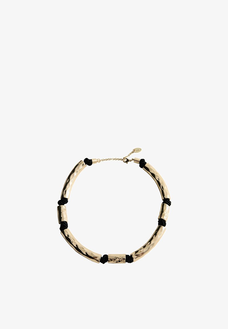 Des perles en métal courbées de couleur dorée reliées par des nœuds noirs forment un collier ras du cou avec une chaîne ajustable.