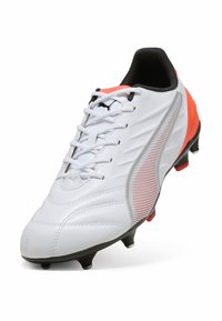 Scarpina da calcio bianca con dettagli neri e arancioni, tomaia in sintetico testurizzato, chiusura con lacci e tacchetti in gomma stampata per una migliore trazione.