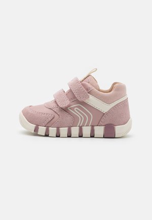 Scarpa sportiva rosa con materiali in suede e mesh, dotata di doppie cinghie in Velcro, una striscia bianca accentuata e una suola in gomma texturizzata.