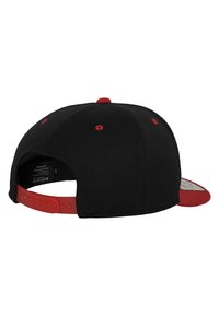 Sort snapback kasket med rød skygge og knap. Har røde øjenlåg og et plastjusterbart bånd bagpå. Tekstureret stofkonstruktion.