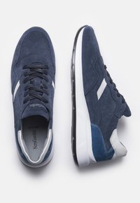 Le sneakers in suede blu navy presentano dettagli bianchi e blu chiaro, lacci neri e una superficie texturizzata con una suola ammortizzata.