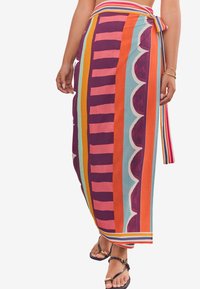 Multi-colored wrap skirt featuring bold stripes and scalloped patterns in purple, orange, aqua, and pink, with a tied waist detail.
