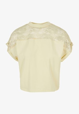 Rövid ujjú, puha sárga pamut felső, csipkés hátpanellel, lekerekített nyakkivágással és laza szabással, alkalmas mindennapi viseletre.
