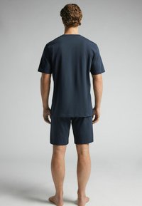 Marineblaue Kurzarm-T-Shirt und passende Shorts aus leichtem Stoff, glatter Textur, lockerer Passform, schlichtes Design und keine sichtbaren Muster.