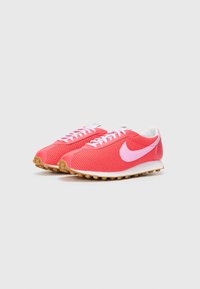 Crvene i ružičaste mrežaste tenisice s bijelim vezicama, s ružičastim swoosh logom i gumenim potplatom s teksturiranim gripom.