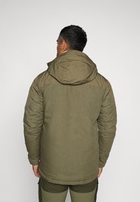 Olijfgroene geïsoleerde jas met een capuchon, met een gladde textuur, ritssluiting en zichtbare stikseldetails. Achteraanzicht weergegeven.
