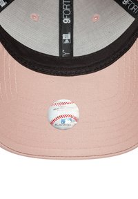 Rosa Kappe mit einem schwarzen Schirm, auf der Innenseite befindet sich ein runder MLB-Authentizitätsaufkleber. Der Stoff hat eine strukturierte Oberfläche.