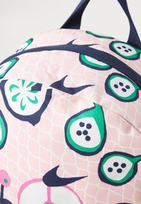Rosa Rucksack mit einem lebhaften Design in Grün und Marineblau. Strukturierter Stoff mit Obstmustern und einem oberen Griff zum Tragen.