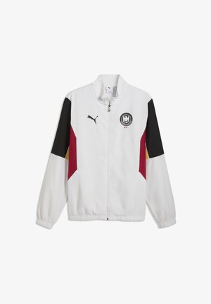 Vit sportjacka med dragkedja, med svarta, röda och gyllene detaljer på ärmarna, elastiska muddar, Puma-logotyp och en svart örnemblem på bröstet.