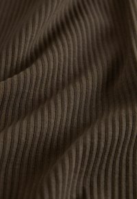 Braunes, strukturiertes Rippstoff mit feinen vertikalen Linien und einem weichen Erscheinungsbild, das eine glatte, gemütliche Textur zeigt.