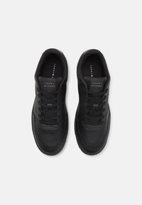 Sorte syntetiske lærersneakers med en glatt overflate, rund tå, snøring og preget logo på tungen. Perforerte detaljer langs sidene.