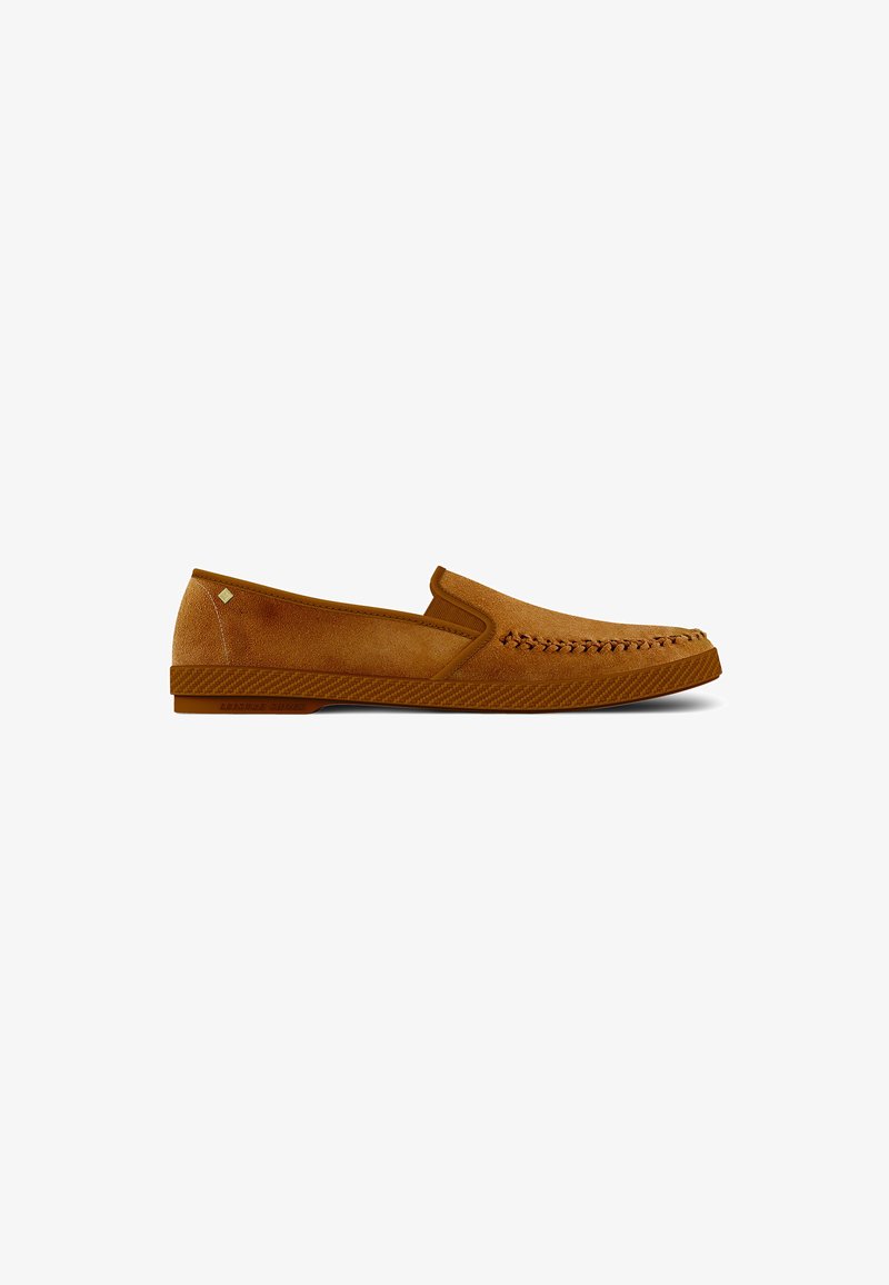 Suede slip-on shoe in light brown, featuring decorative stitching along the toe, textured rubber sole, and subtle branding on the side.