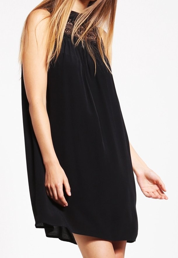 Czarna, bezrękawnikowa sukienka o luźnym kroju, z koronkowymi zdobieniami wokół szyi, gładką fakturą oraz dłuższym tylnym dołem.