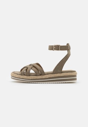 Åben tå sandal i olivengrøn med krydsede stropper. Har en jute-indpakket sål og en spændeankelrem. Tekstureret overflade.