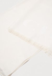 Bela šala z teksturiranim, franjastim robom. Ima subtilen embosiran vzorčast logotip, kar kaže na mehko tkanino in gladek zaključek.