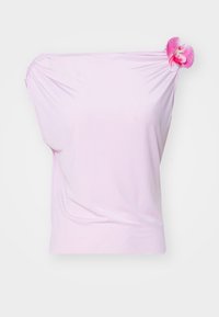 Top rosa scollato sulle spalle realizzato in tessuto liscio, con un'aggiunta floreale sulla spalla destra e dettagli arricciati sul lato sinistro.