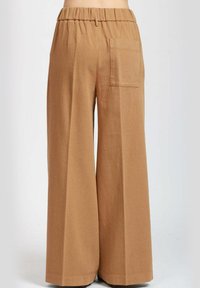 Pantaloni in lino a gamba larga di un caldo colore marrone. Vita elastica, dettaglio della tasca posteriore e texture morbida.