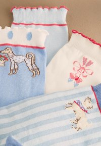 Négy pasztellszínű baba zokni fodros széllel, kutya és masni mintákkal bézs alapon.