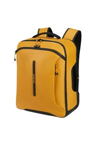 Sac à dos jaune avec des accents noirs, fabriqué dans un matériau lisse ; il possède une poche frontale zippée, des bretelles ergonomiques et un design structuré.