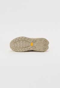 Talpa de pantof din cauciuc bej cu modele adânci de profil. Dispune de un logo galben Vibram, care indică aderență durabilă pentru diverse suprafețe.