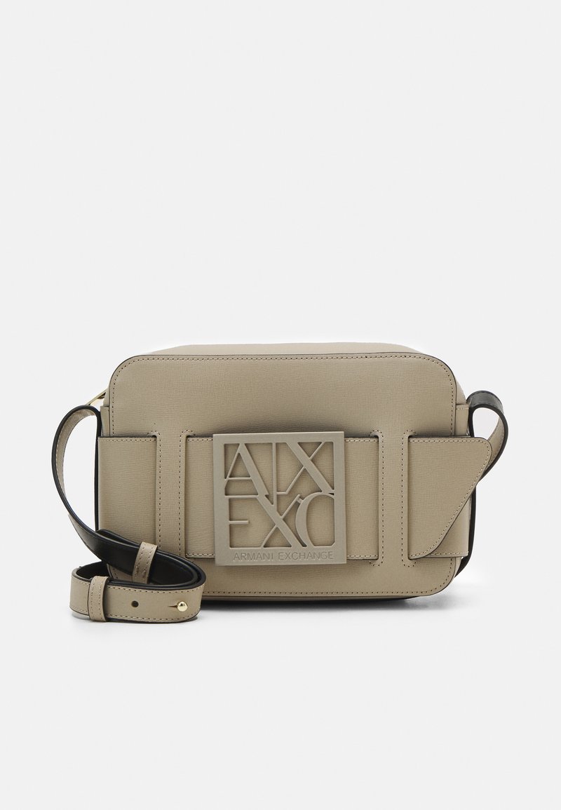 Beige strukturiert Umhängetasche mit einem auffälligen, erhabenen Logo-Detail. Mit einem schwarzen Tragegurt und einer rechteckigen Form mit schrägen Klappen.
