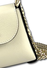 Sac à épaule en cuir beige avec une finition texturée, bord noir et une bandoulière en chaîne dorée métallisée. Doté d'une fermeture à rabat.